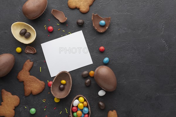 Top view chocolate easter eggs with colorful candy copy space