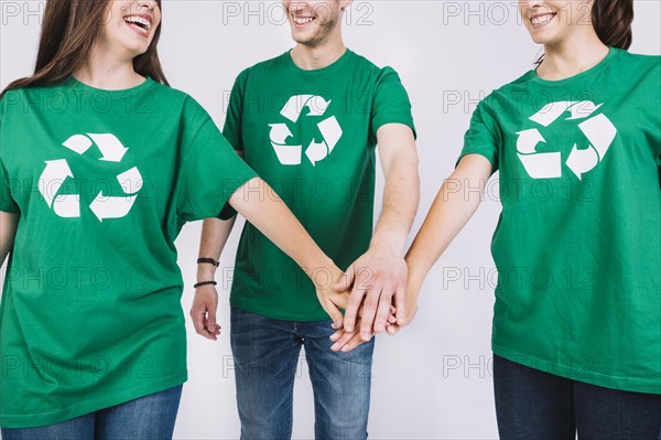 Group friends green t shirt stacking their hands