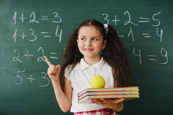 Schoolgirl pointing up blackboard