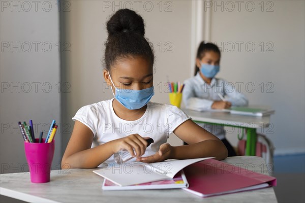 Little girl disinfecting her hands class