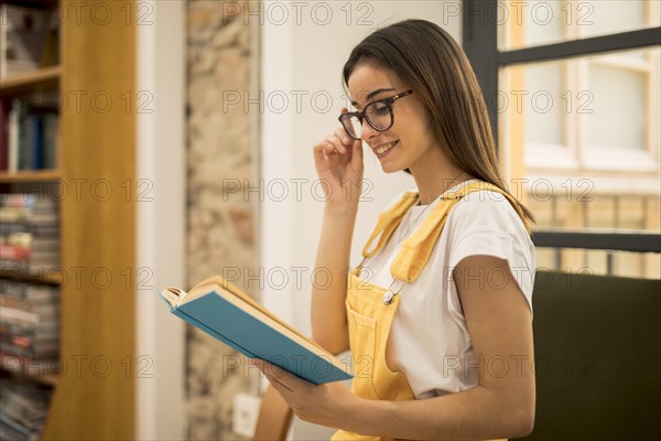 Attractive young woman reading book library