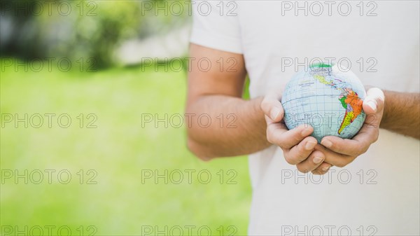 Mid section man holding globe hand