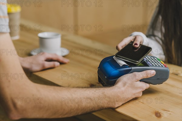 Barista accepting payment with smartphone