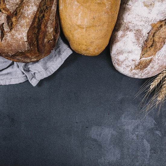 Overhead view rustic loaf breads black counter top