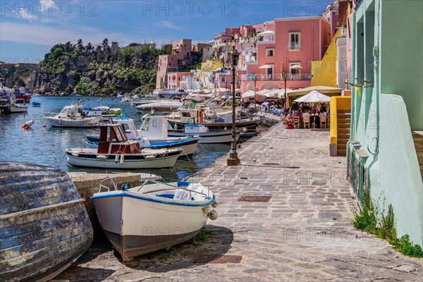 Shore path with fishing boats and fishing harbour of the fishing village Corricella