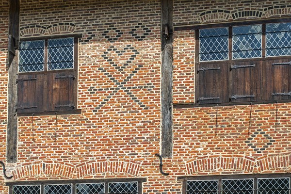 Flemish mason's symbols in brickwork on facade of 16th century brick house showing checks