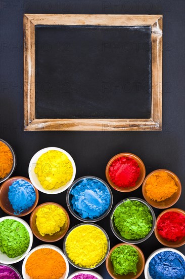 Wooden slate with color powder bowls black backdrop