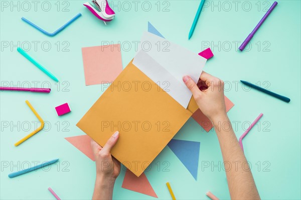 Female hand removing card from envelope stationery accessories