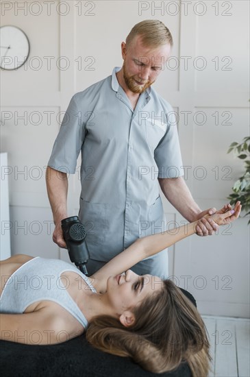 Male physiotherapist with female patient equipment during physical therapy session