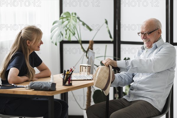 Smiley senior man nursing home with nurse