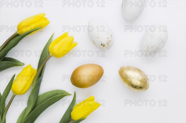 Flat lay golden easter eggs with flowers