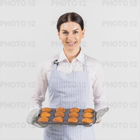 Pastry chef female smiling with muffin tin