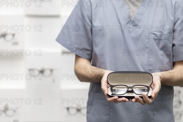 Front view man holding pair glasses case