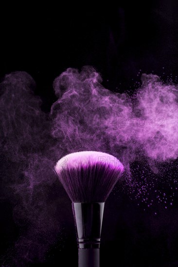 Makeup brush with neon fuchsia powder mist