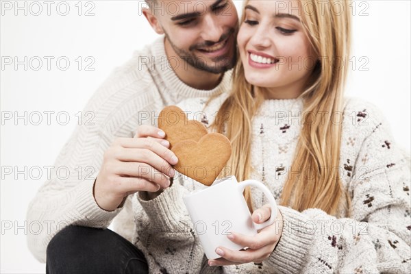 Couple dipping cookies into mug