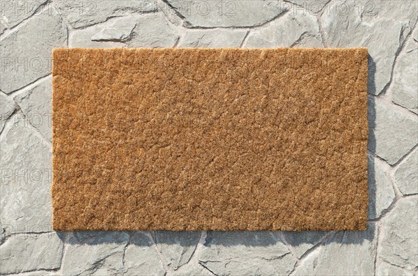 Overhead of blank doormat on the rock tile porch