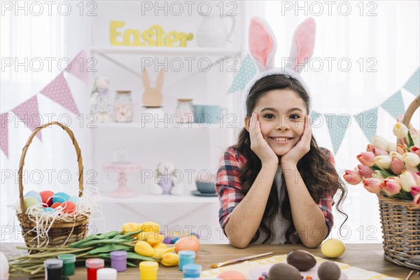 Portrait girl with easter eggs paint tulips flowers table