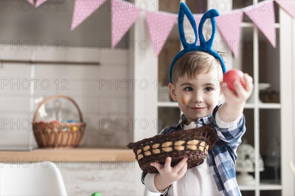 Portrait cute young boy holding easter egg