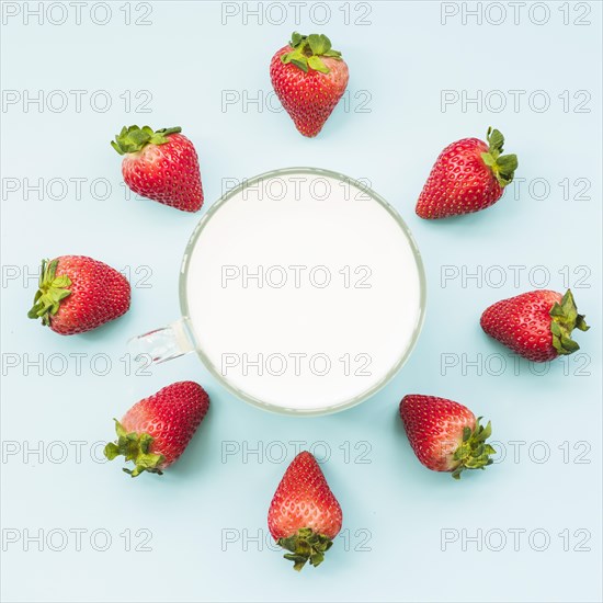 Overhead view strawberries milk blue backdrop