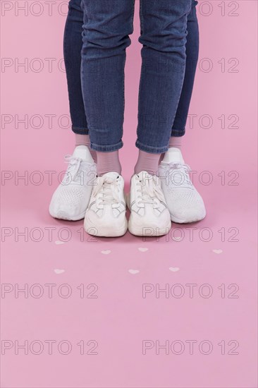Man woman legs jeans sneakers near decorative hearts