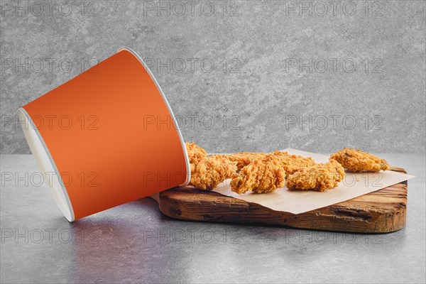 Deep fried chicken wings basket in breading scattered on parchment paper