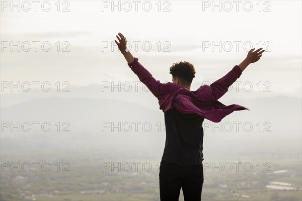 Rear view young man with raised hand