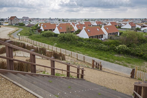 The wooden footbridge Het Wrakhout and holiday resort along the North Sea coast at Westende