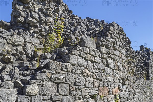 Thick stone wall of medieval castle showing two types of masonry