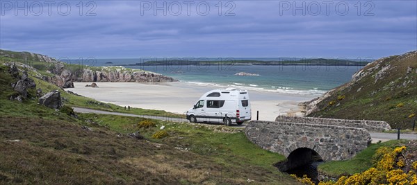 Motorhome driving on desolate road past Ceannabeinne Beach in summer near Durness