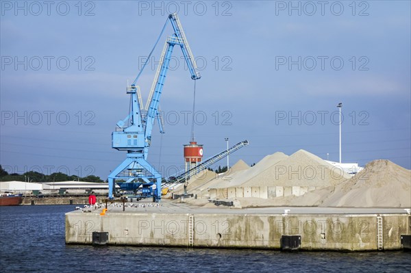 Dock crane and heaps of sand at the Ch. Kesteleyn gravel terminal in the port of Ghent