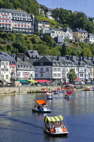 Paddle boats with tourists on the Semois river in the city Bouillon in summer
