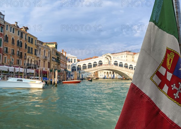 Beautiful view of Italian maritime flag and bridge of Rialto or ponte Rialto on Grand Canal on Venice