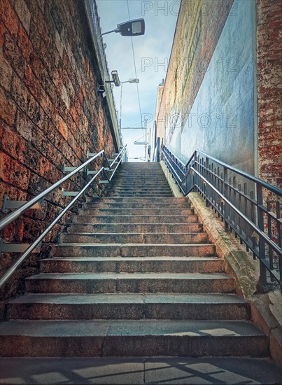 Narrow outside stairway between the walls. Abstract view upstairs