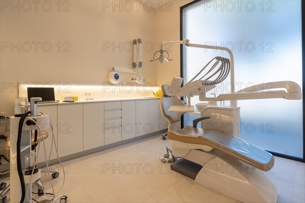 Interior space with no people of a dental clinic room with a chair and tools