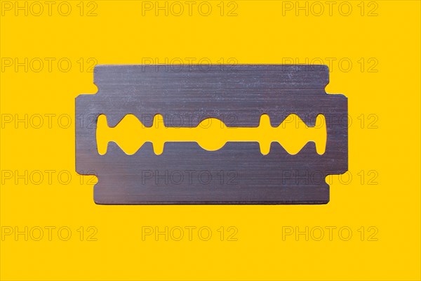 Razor blade against yellow background