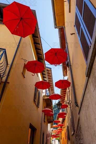 City Street in Porto Ceresio with Hanging Umbrellas in a Sunny Summer Day in Porto Ceresio