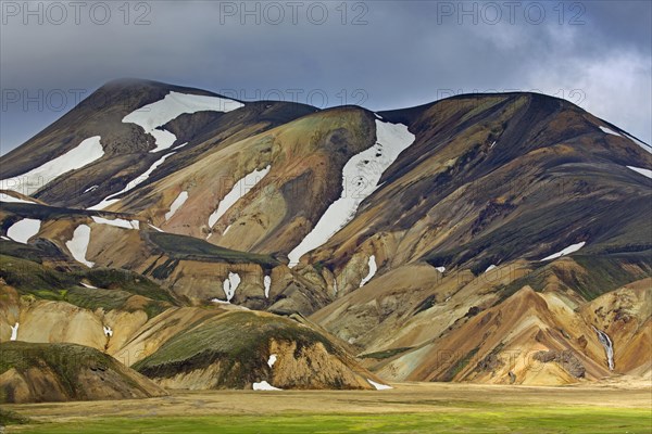 Sulphur coloured rhyolite mountains with patches of snow at Brennisteinsalda volcano near Landmannalaugar