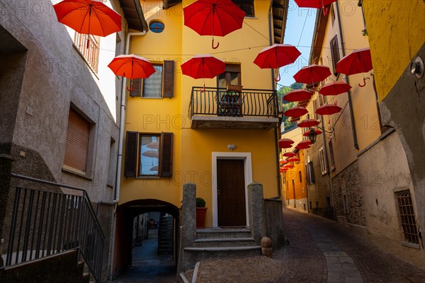 City Street in Porto Ceresio with Hanging Umbrellas in a Sunny Summer Day in Porto Ceresio