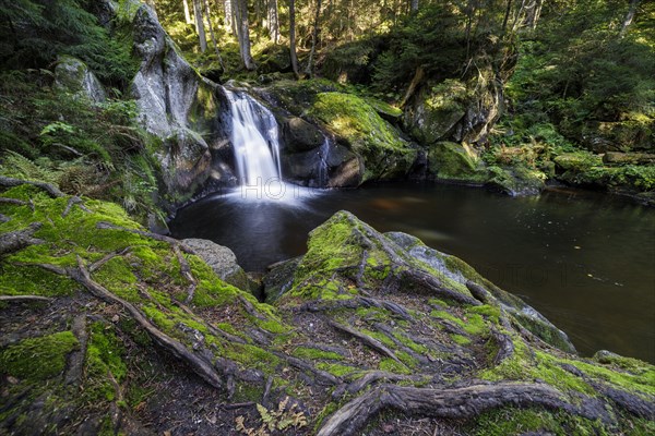 Waterfall in autumn forest with rocks