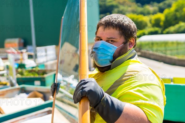 Worker in a recycling factory or clean point and garbage with a face mask and with security protections