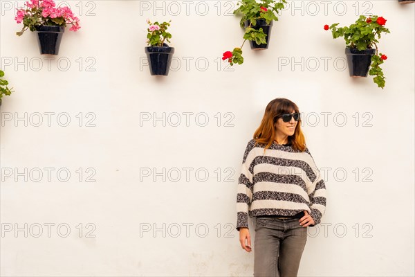 Portrait of a young tourist in the pots with flowers in the white houses of the town of Nerja