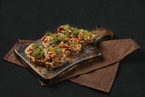Sandwich with chanterelle mushrooms on black background