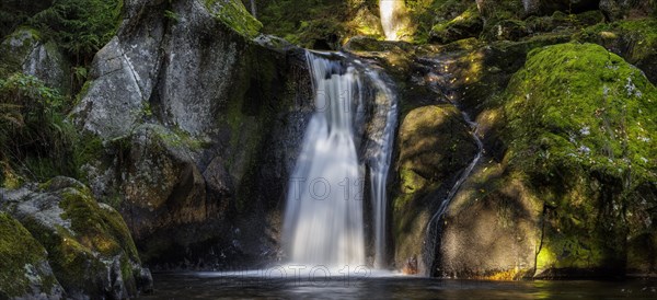 Waterfall in autumn forest with rocks