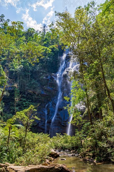Waterfall between rocks and trees in the rainforest in the state of Minas Gerais