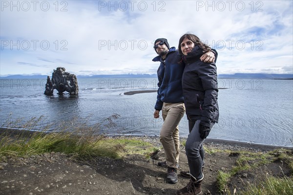 A couple in stone dinosaur in the sea at Hvitserkur