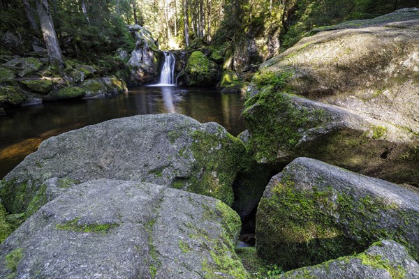 Waterfall in autumn forest with rocks