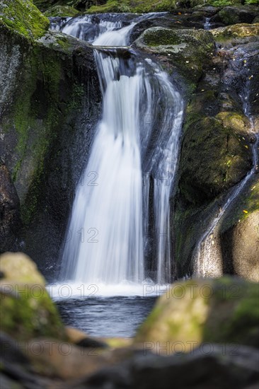 Waterfall in autumn forest with rocks
