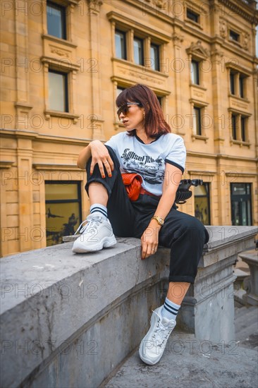 Lifestyle in the city. A young brunette in sunglasses