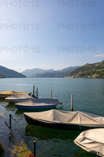 Port with Boats in Brusino Arsizio on the Waterfront in a Sunny Summer Day on Lake Lugano and Mountain View over Morcote