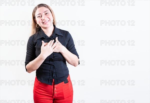 Thankful young woman with hands on chest. Grateful teenage girl smiling with hands on chest isolated. Positive latin girl with hands on chest